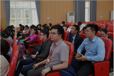 A group of people sitting in red chairs

Description automatically generated